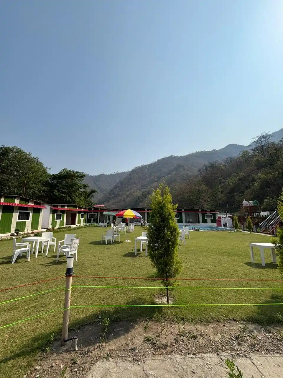 Spacious green lawn with cottages and mountain view at RS01 resort in Rishikesh