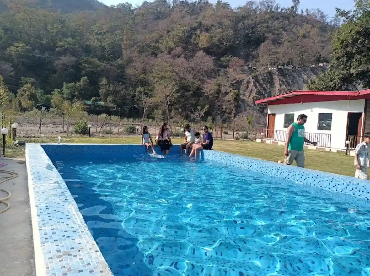 Guests relaxing at outdoor swimming pool with mountain view at RS03 resort