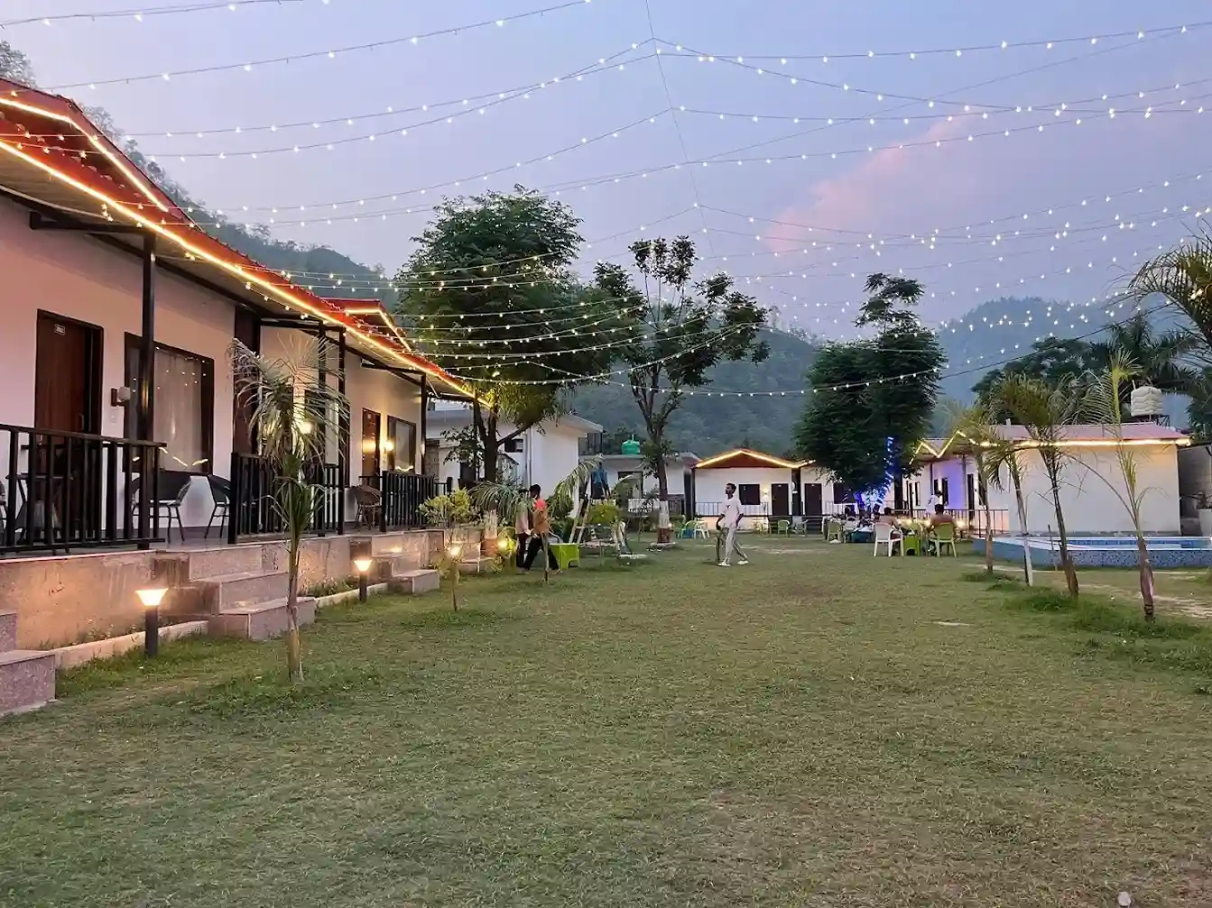 Evening lawn with cottages and decorative lights at RS05 resort