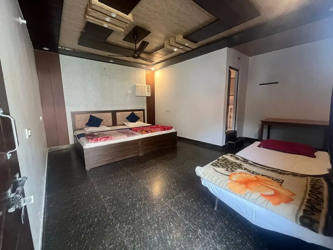 Spacious family room with multiple beds and modern ceiling design at RS05 resort