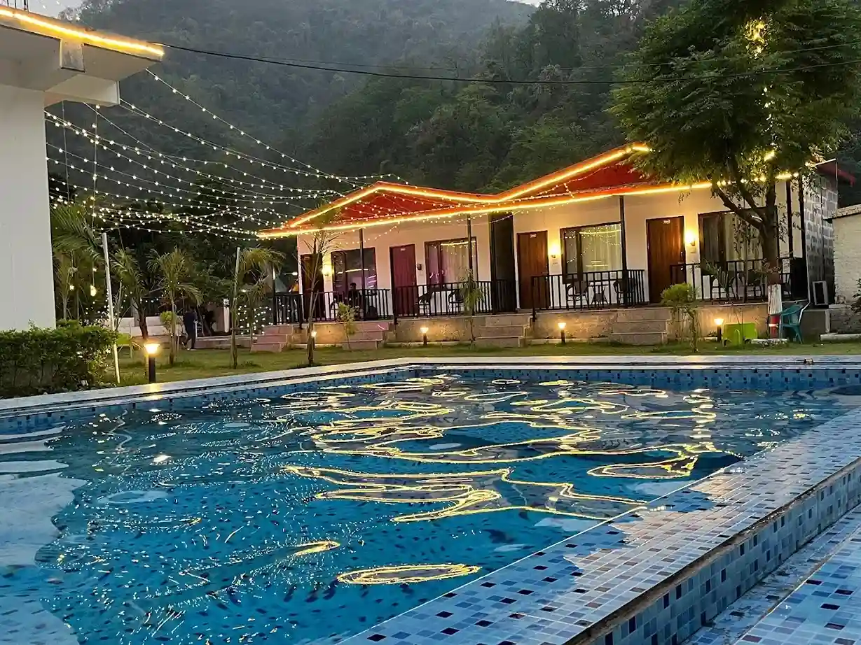 Swimming pool with illuminated cottages at night at RS05 resort