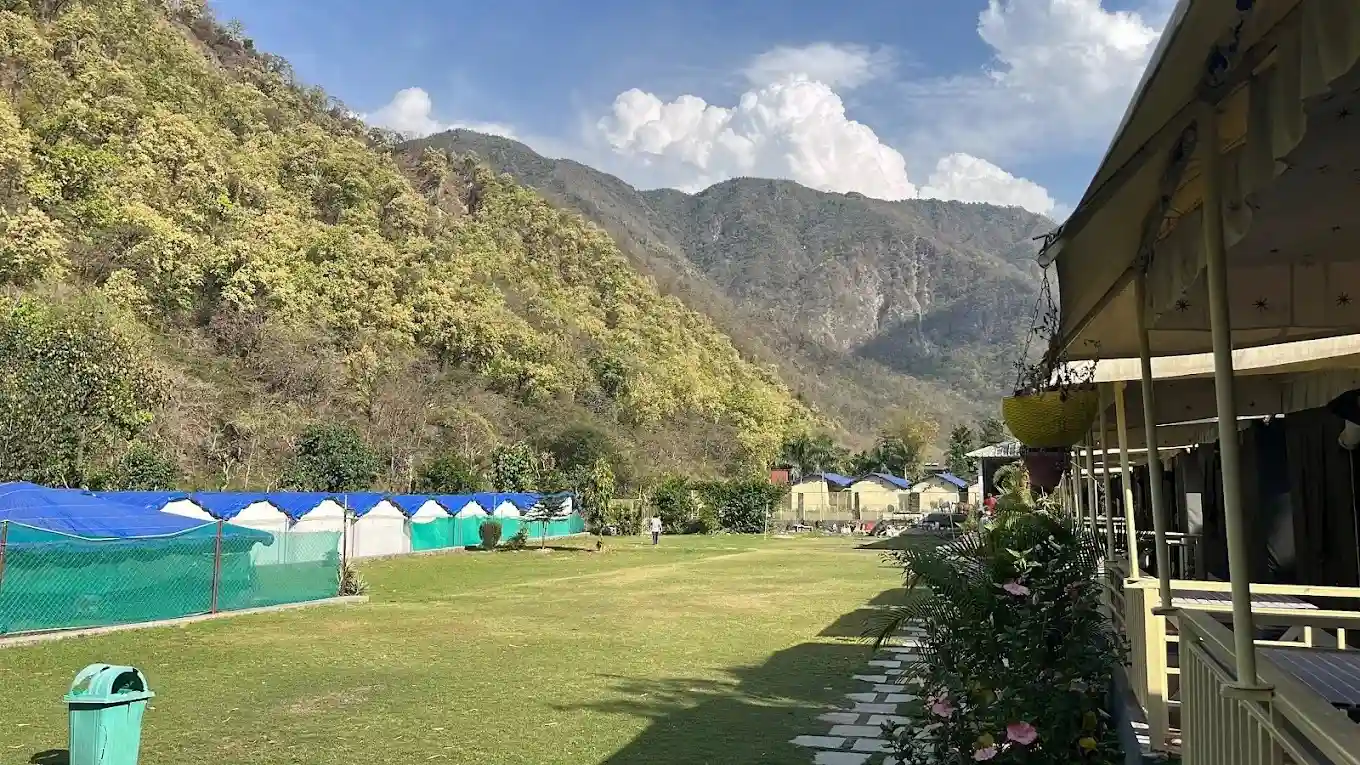 Open green lawn with Swiss tents and mountain view at RS07 resort