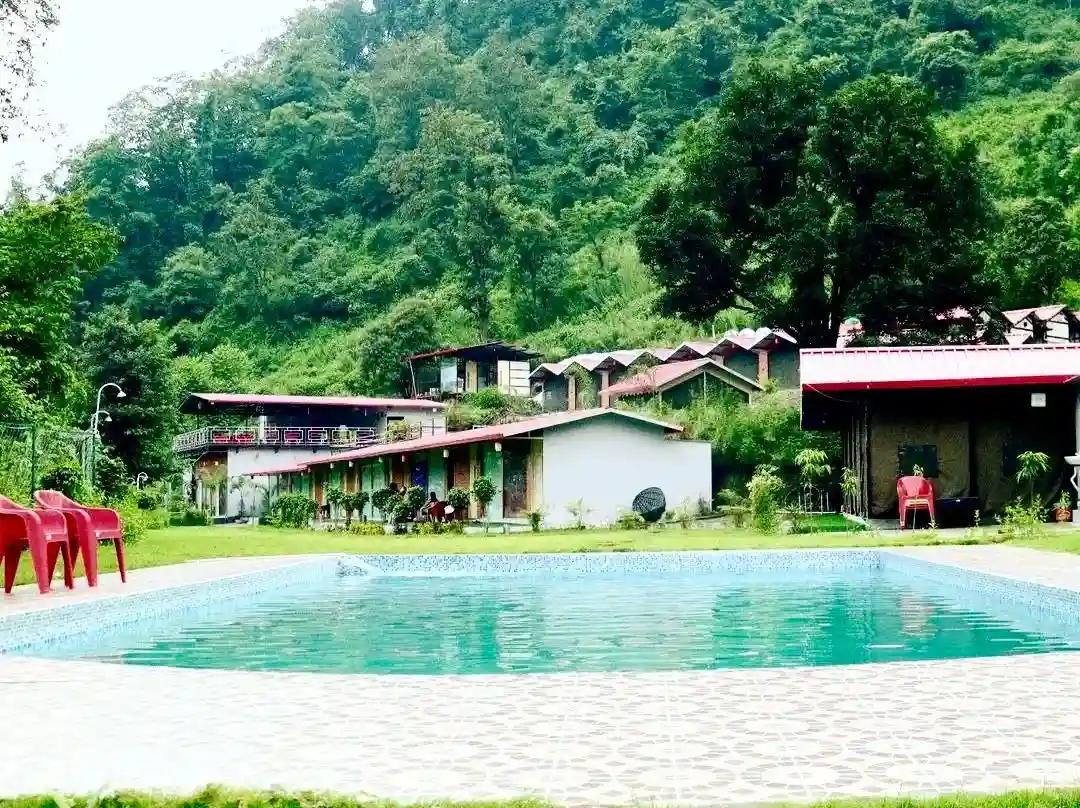 RS09 outdoor swimming pool with hillside cottages in Shivpuri Rishikesh