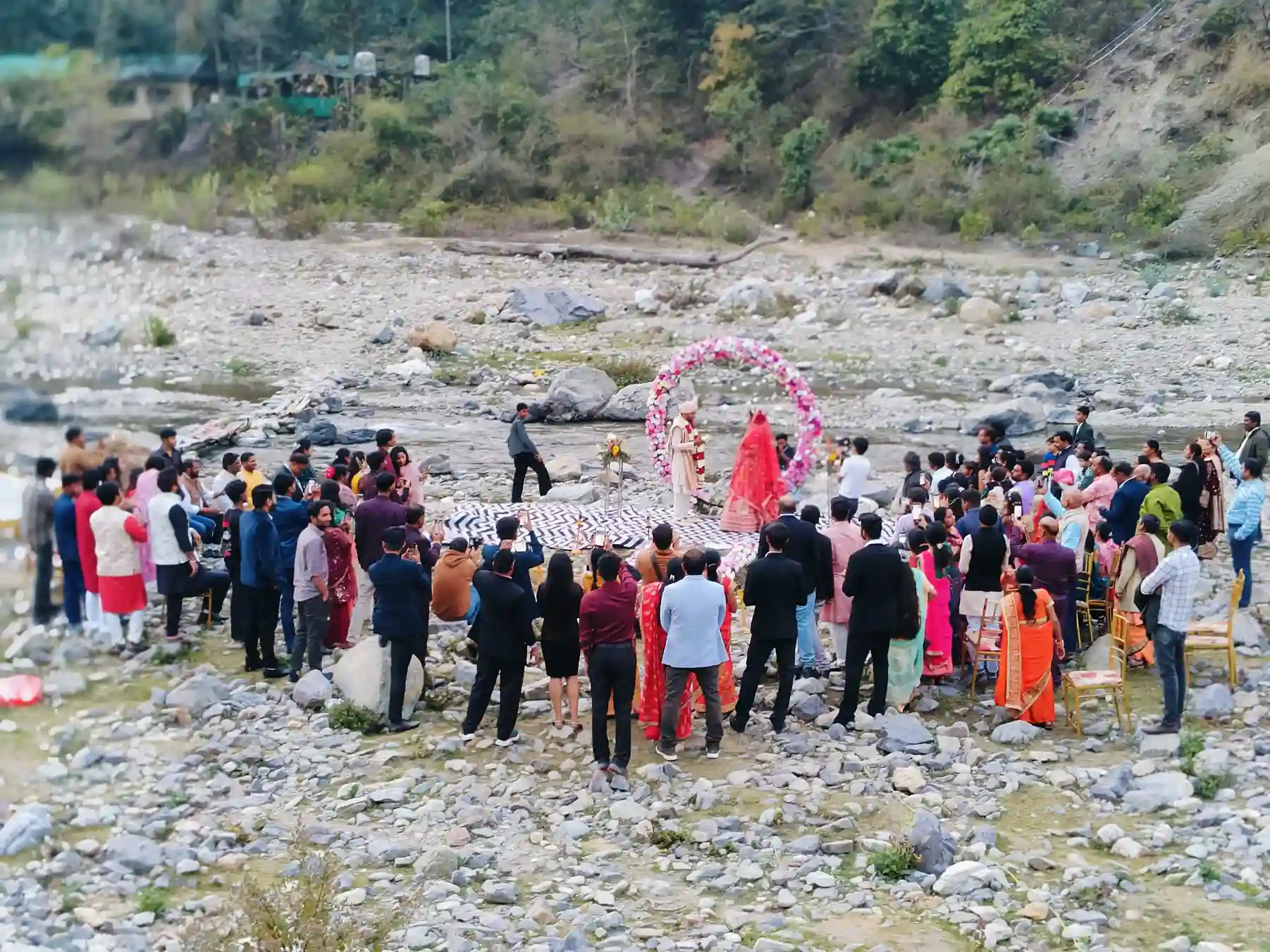 Riverside destination wedding ceremony at RS01 resort in Rishikesh with guests and mountain backdrop