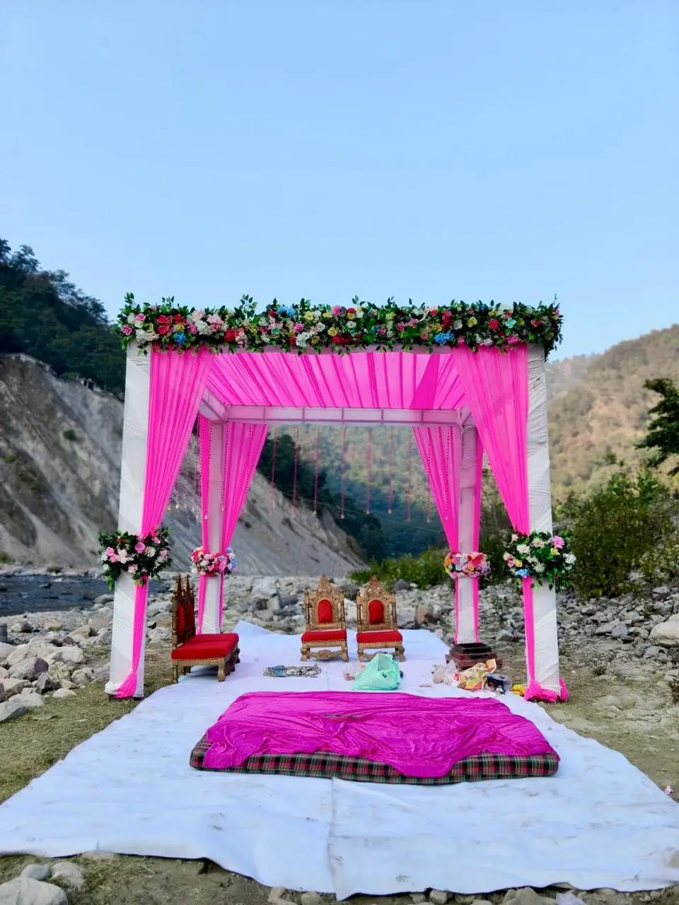 Riverside destination wedding mandap setup at RS03 resort in Rishikesh with pink drapes and mountain backdrop