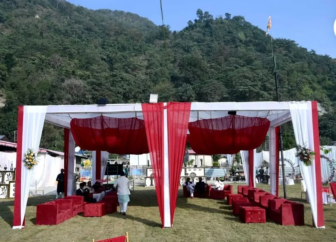 Outdoor wedding seating arrangement in Rishikesh with red and white decor, hill station destination wedding setup
