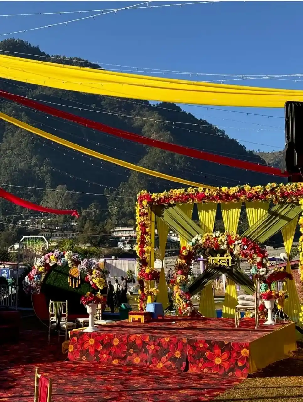 Colorful mehendi wedding stage decor in Rishikesh with floral mandap and mountain view destination wedding
