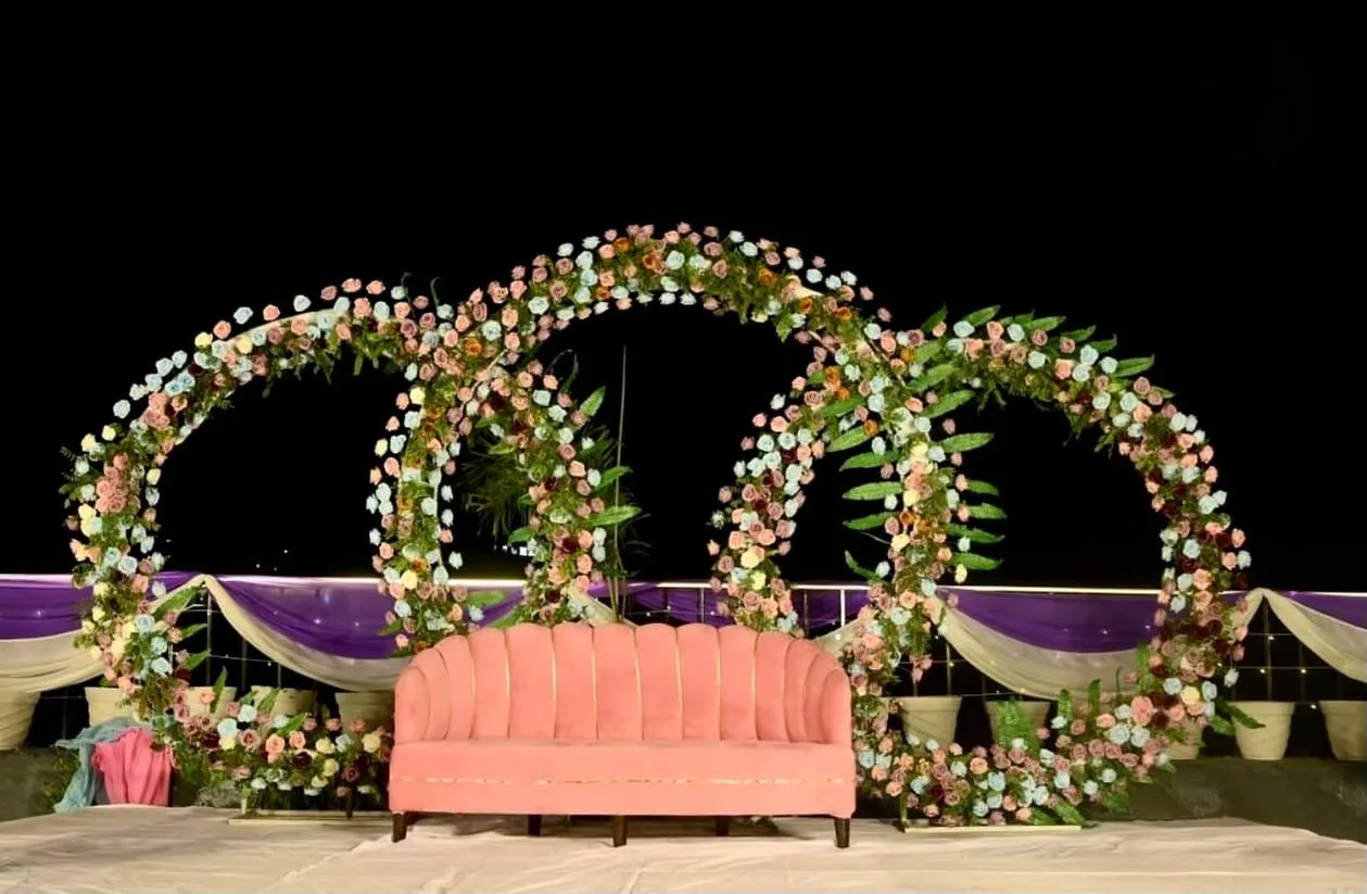 Night destination wedding decor in Rishikesh featuring floral ring backdrop and elegant stage setup