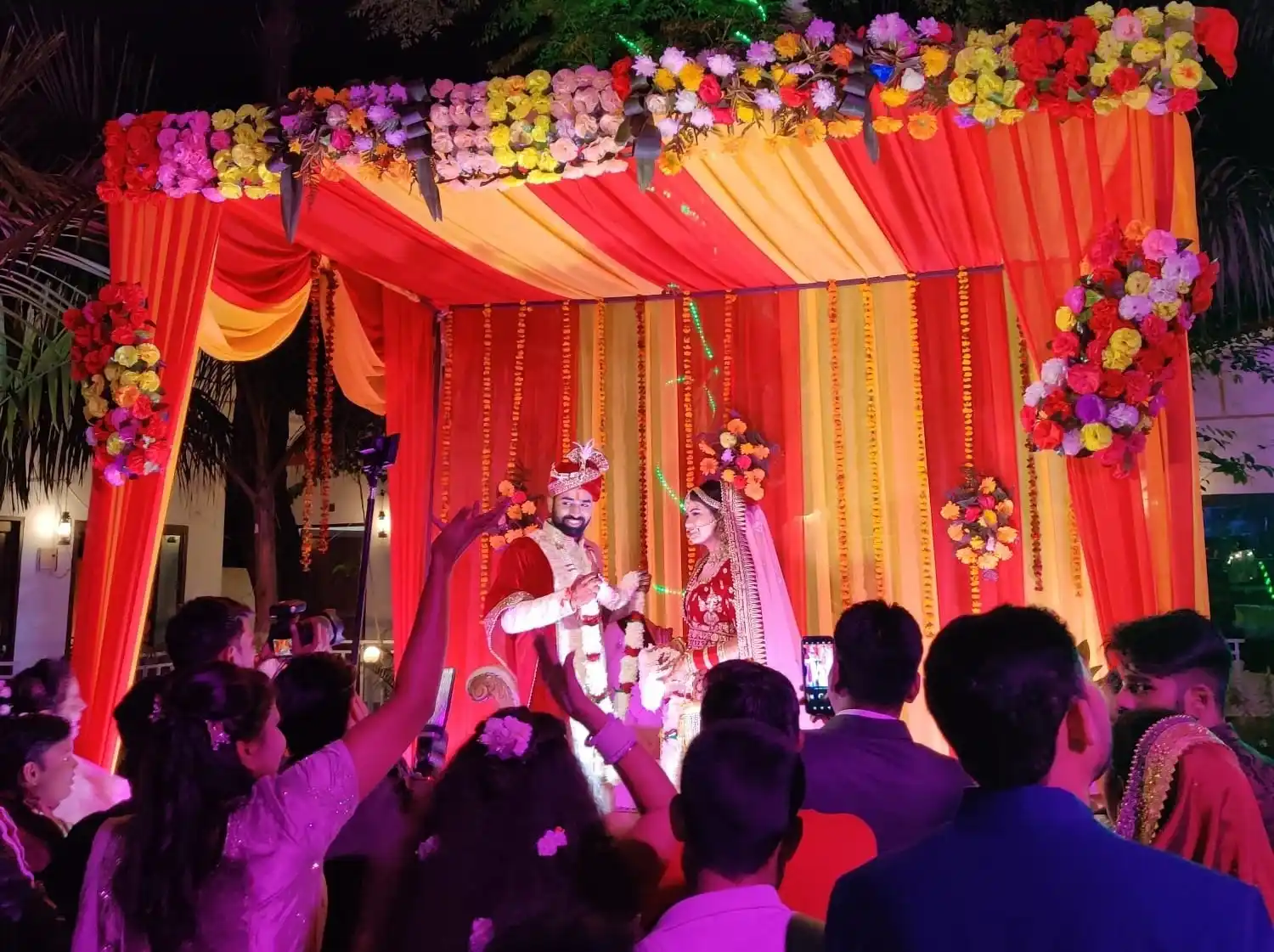 Bride and groom exchanging varmala during destination wedding ceremony at RS08 resort in Rishikesh with floral mandap